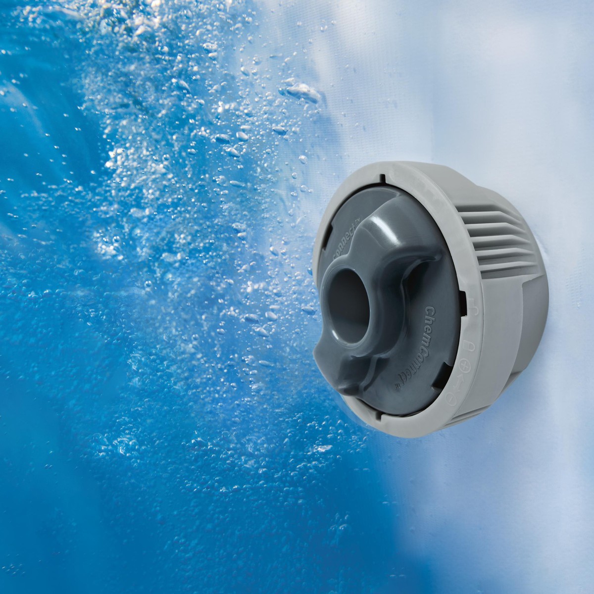 Zbliżenie na zamontowany wewnątrz jacuzzi dozownik chemii ChemConnect pod wodą. Wokół urządzenia widoczne są liczne pęcherzyki powietrza generowane przez system AirJet.